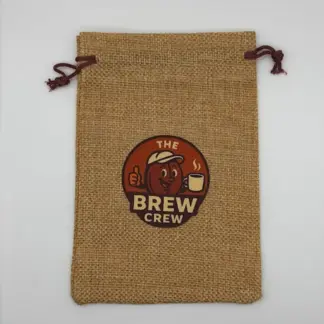 Mini burlap drawstring bag with whimsical "The Brew Crew" coffee bean logo, sustainable and reusable for car coffee aroma freshener